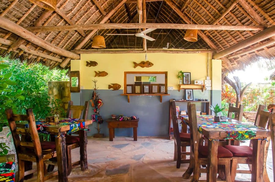 Thatched restaurant with wooden tables and local decoration