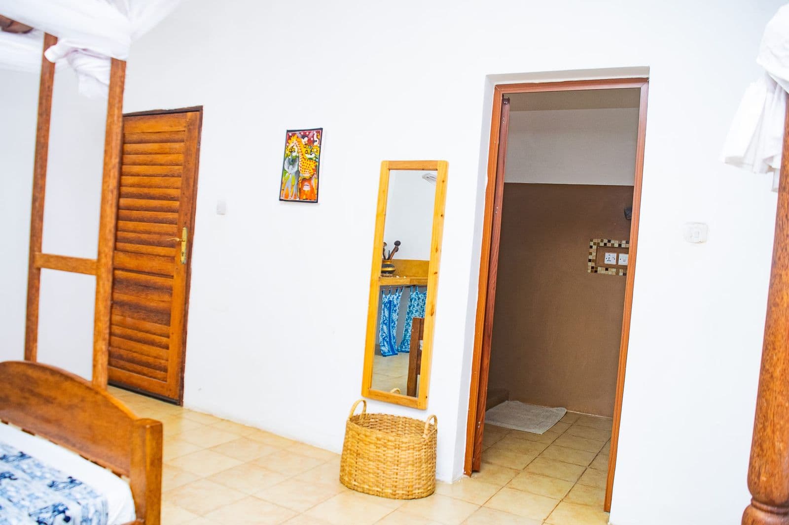 Bedroom with a wooden door, mirror and en-suite bathroom